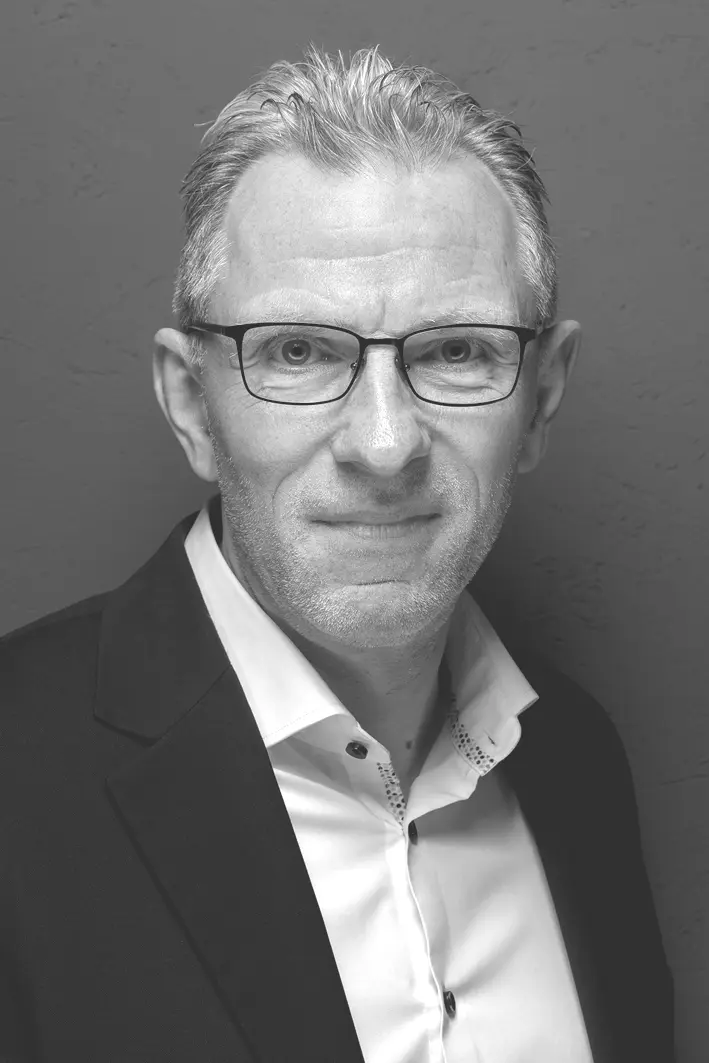 Porträtfoto von Dieter Pfenning, IT-Strategieberater: Mann mit Brille, kurzem grau meliertem Haar und dunklem Sakko über weißem Hemd, schwarz-weiß